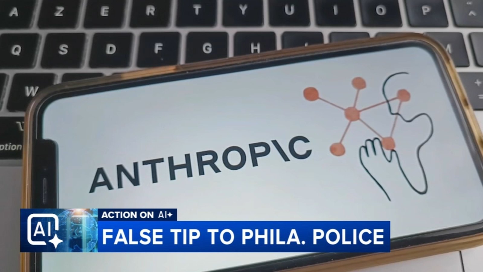 Capture d'un reportage télévisé : un smartphone affiche le logo d'Anthropic, avec le bandeau « False tip to Phila. Police ».