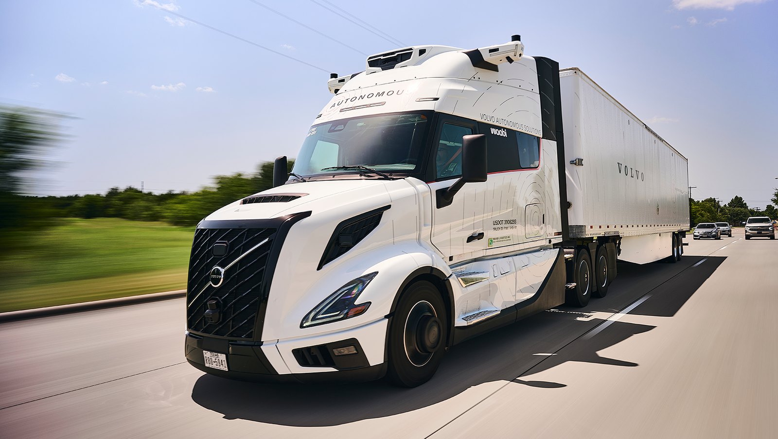 Camion Volvo VNL Autonomous blanc aux couleurs de Volvo Autonomous Solutions et Waabi, roulant sur une route du Texas.